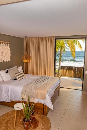 a bedroom with a bed and a view of the ocean at Fishermans Resort Life in La Libertad