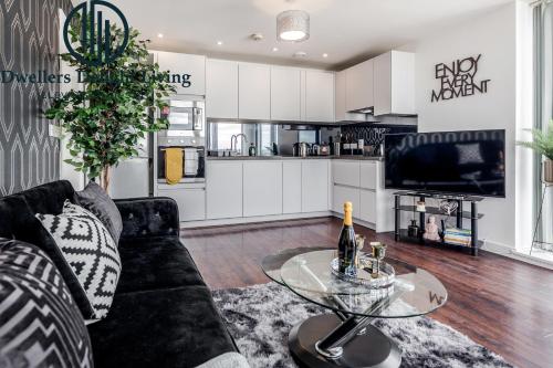 Basildon - Dwellers Delight Living Ltd Serviced Accommodation , 2 Bedroom Penthouse Basildon Essex with Free Wifi & secure parking في باسيلدون: غرفة معيشة مع أريكة سوداء وطاولة