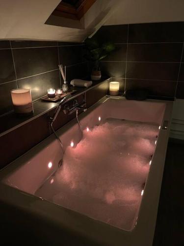 a bathroom with a bath tub with lights in it at Suites Mana - La Perle des Isles , Superbe maison Art déco avec balnéothérapie in Rethel
