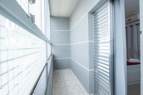 uma casa de banho com uma cabina de duche ao nível do chão e uma janela em Expo Hotel em São Paulo