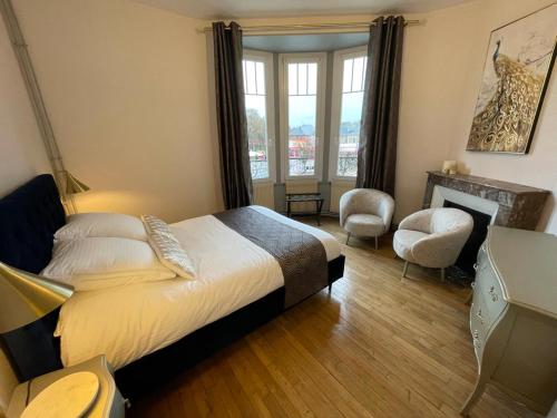 a bedroom with a large bed and a fireplace at Suites Mana - La Perle des Isles , Superbe maison Art déco avec balnéothérapie in Rethel