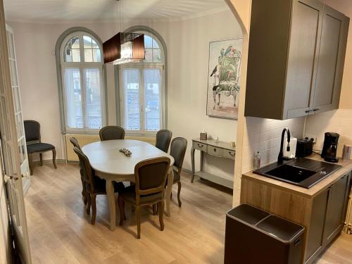 a kitchen and dining room with a table and chairs at Suites Mana - La Perle des Isles , Superbe maison Art déco avec balnéothérapie in Rethel