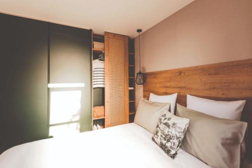 1 dormitorio con 1 cama con almohadas blancas en Chalet Teifëlslee, en Goebelsmuhle
