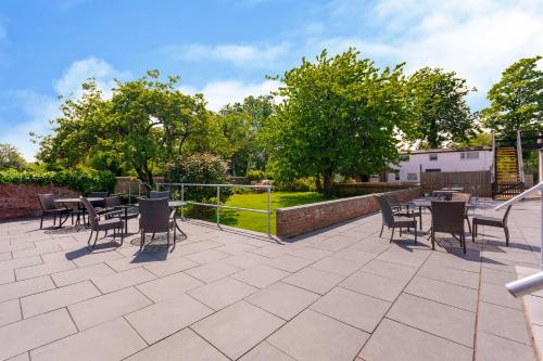 a patio with a bunch of chairs and tables at Woodcote Hotel in Hooton