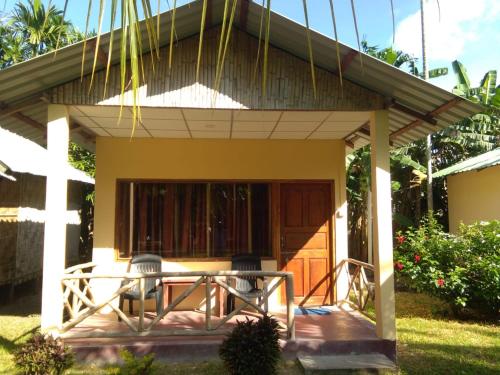 una piccola casa con portico con tetto di Green Imperial a Port Blair