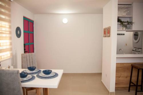 a dining room with a white table with blue dishes on it at Apartamento Duplex - Aqua Guatape in Guatapé