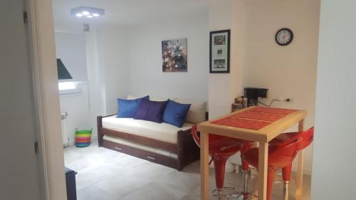 Departamentos Paradise في ريو غراندي: غرفة معيشة مع سرير وطاولة وأريكة