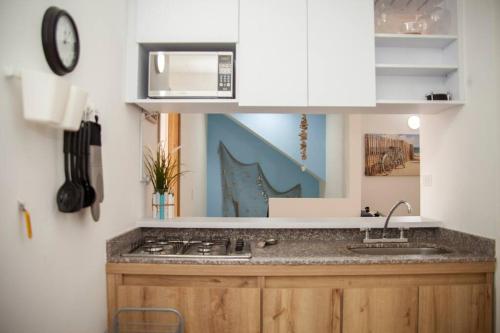eine Küche mit einer Spüle und einer Mikrowelle in der Unterkunft Duplex Familiar Apartment Aqua in Guatapé