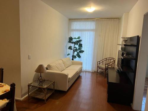 sala de estar con sofá blanco y mesa en Apartamento Temporada Barra da Tijuca en Río de Janeiro