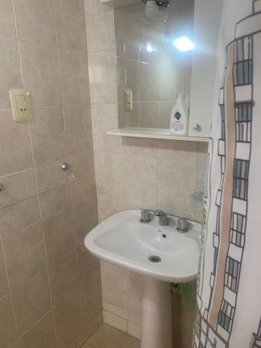 a bathroom with a white sink and a shower at Depto Gales, a 1 cuadra del mar in Puerto Madryn