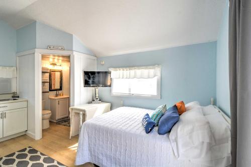 - une chambre avec un lit blanc et des murs bleus dans l'établissement Charming Tiny Cottage with Boat Dock on Crooked Lake, 