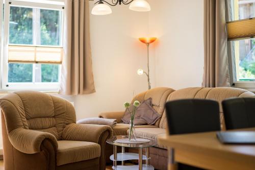 a living room with a couch and two chairs and a table at Ferienanlage Zum Wildbach Schierke in Schierke