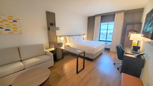 a hotel room with a bed and a couch at Comfort Inn & Suites Panama City Beach - Pier Park Area in Panama City Beach