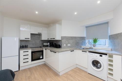 a kitchen with white cabinets and a dishwasher at Central City Stay - 1 Bed Apartment in Aberdeen in Aberdeen