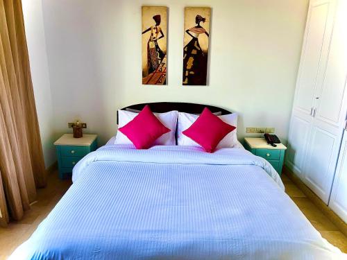 een slaapkamer met een groot bed met roze kussens bij South Marina Apartment Wi-Fi available in Hurghada
