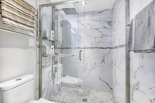 uma casa de banho com uma cabina de duche em vidro e um WC. em Charming and Luxurious 2BR+1Bath Guest Suite em Toronto
