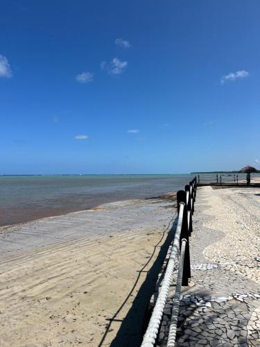 a row of benches on a beach near the water at Village Galés de Maragogi in Maragogi