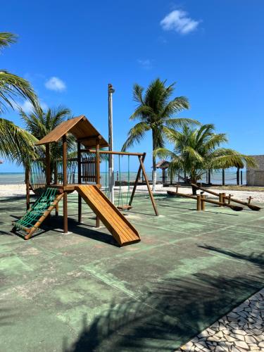 a playground on the beach with palm trees at Village Galés de Maragogi in Maragogi