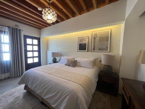 a bedroom with a white bed and a chandelier at Hotel Boutique Rincón de Luna in San Juan del Río