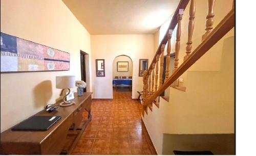 a hallway with a staircase and a desk with a lamp at Casa Rural Finca Paraíso. Heated pool in Vilaflor