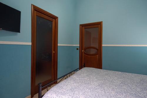 ナポリにあるSpaccaNapoli Homeのベッドルーム1室(ベッド1台、壁にテレビ付)