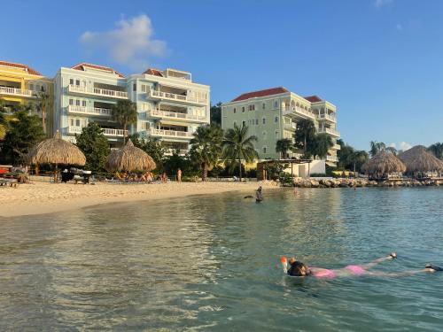 a woman laying in the water at a beach at Tip! Blue Bay Beachvilla 12 - Blue Bay Resort in Sint Michiel