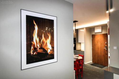 a picture of a fireplace on a wall in a living room at D Apartments Centrum Ogień in Białystok