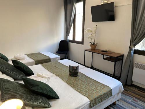 a hotel room with two beds and a television at Gabrielle hôtel in Aiguines