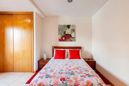 a bedroom with a bed with red pillows at Casa de Balinhas - Gerês in Cova