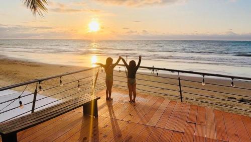 two people standing on a deck looking at the ocean at Vacaciones Playa Azul in Tonsupa