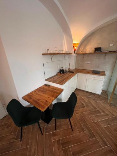 a kitchen with a wooden table and two chairs at Penzion Fara pod Milešovkou in Velemín