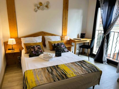 a bedroom with a bed with pillows on it at Gabrielle hôtel in Aiguines