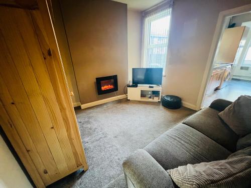 a living room with a couch and a fireplace at Cozy One bedroom house with garden in Luton in Luton