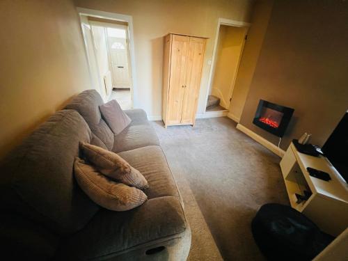 a living room with a couch and a fireplace at Cozy One bedroom house with garden in Luton in Luton