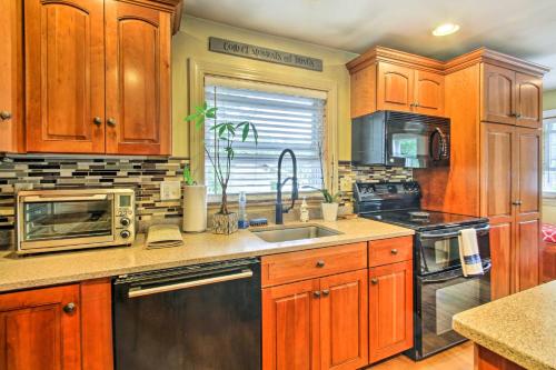 a kitchen with wooden cabinets and a sink at Walk to Beach Maine Home with Hot Tub and Deck! in Old Orchard Beach