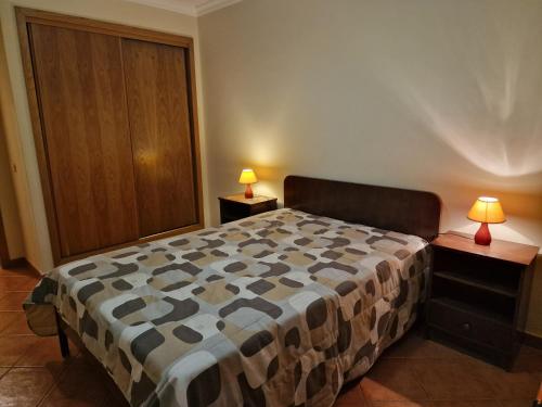 um quarto com uma cama e 2 candeeiros nas mesas em Mar Salgado Apartment em Armação de Pêra