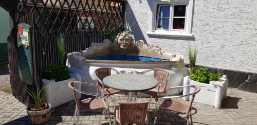 a table and chairs sitting next to a fountain at Restaurant & Pension Liebenstein in Libá