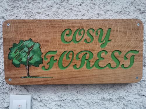 a wooden sign with a tree and the words cosy grass at Cosy Forest in Kranjska Gora