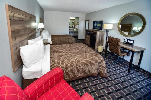 a hotel room with a bed and a red couch at Americas Best Value Inn Douglasville in Douglasville