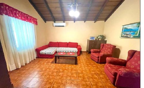 a living room with a red couch and two chairs at Casa Rural Finca Paraíso. Heated pool in Vilaflor