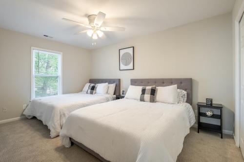 a bedroom with two beds and a ceiling fan at Modern Stunning SouthPark/Cotswold Home! in Charlotte
