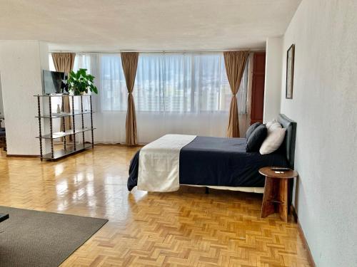 1 dormitorio con cama y ventana grande en Maywa City Center, en Quito