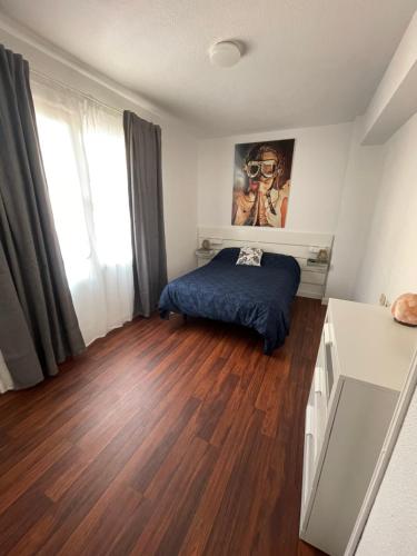 1 dormitorio con 1 cama y suelo de madera en Apartamento Fatima, en Santa Cruz de la Palma