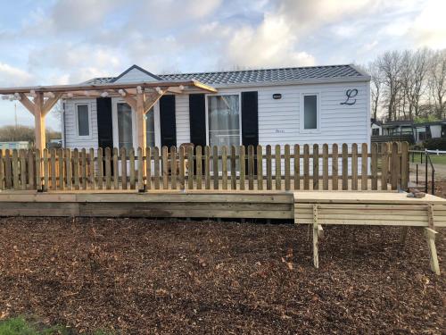 a small white house with a wooden fence at Louisiana in Anloo
