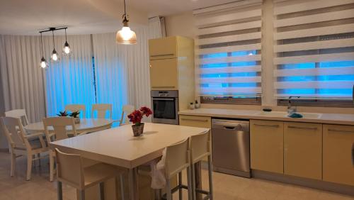 a kitchen and dining room with a table and chairs at אבני החושן- Avnei Hoshen in Nahariyya