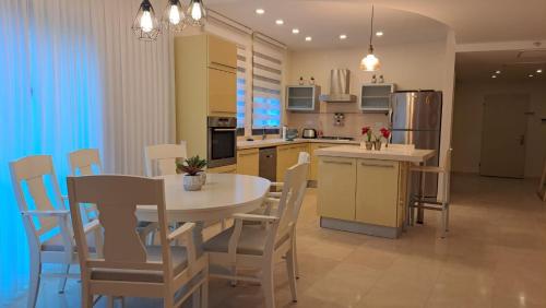 eine Küche und ein Esszimmer mit einem Tisch und Stühlen in der Unterkunft אבני החושן- Avnei Hoshen in Naharija