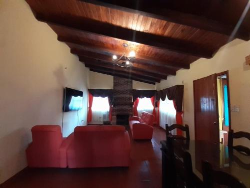 a living room with red furniture and a wooden ceiling at Hotel del Bosque in Panajachel