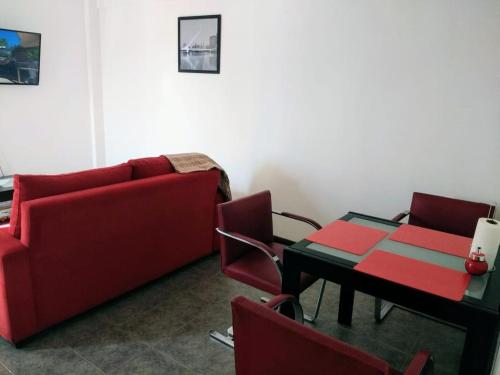 sala de estar con sofá rojo y mesa en Portal del Descanso en Buenos Aires