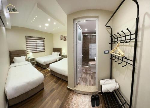 ein Hotelzimmer mit 2 Betten und einem Bad in der Unterkunft Petra Voila in Wadi Musa