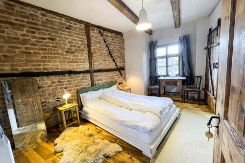 a bedroom with a bed and a brick wall at Michelsberger Haus in Cisnadioara